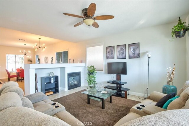 living room featuring light tile patterned floors and ceiling fan with notable chandelier