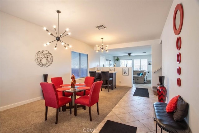 tiled dining space featuring ceiling fan with notable chandelier