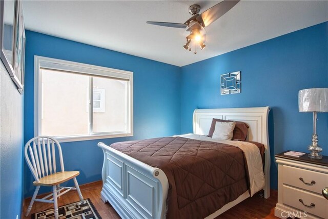 bedroom with ceiling fan and dark hardwood / wood-style flooring