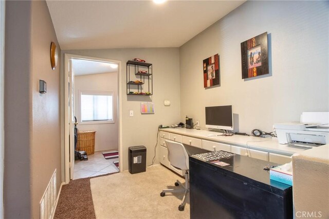 carpeted home office with vaulted ceiling