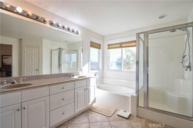 bathroom with tile patterned flooring, vanity, and plus walk in shower