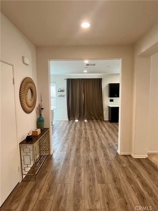 corridor with hardwood / wood-style flooring