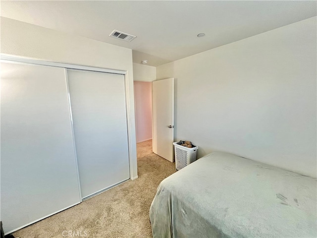 bedroom with light colored carpet and a closet