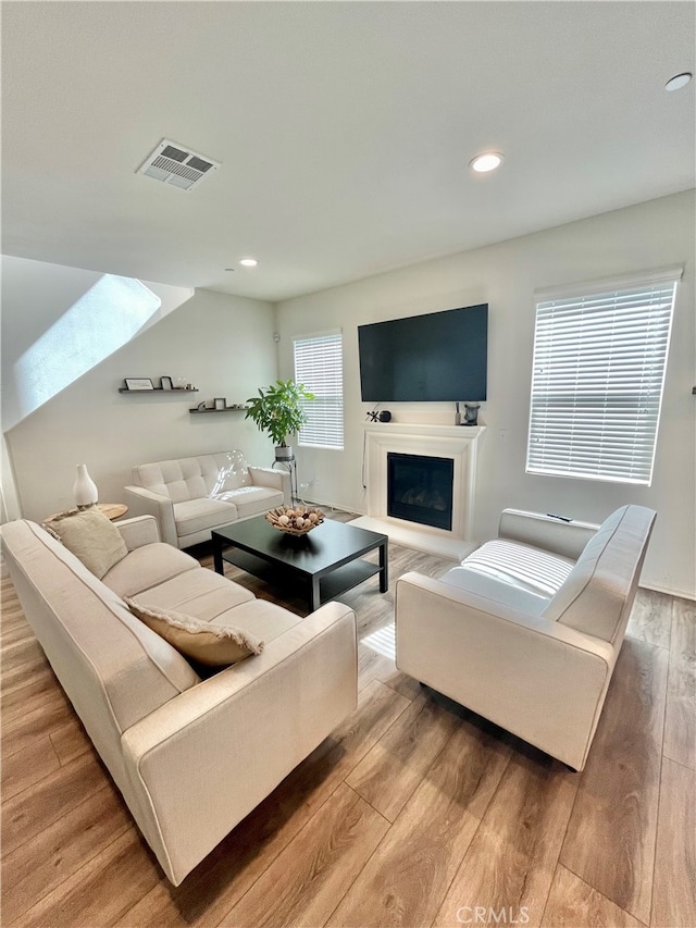 living room with hardwood / wood-style flooring and a skylight