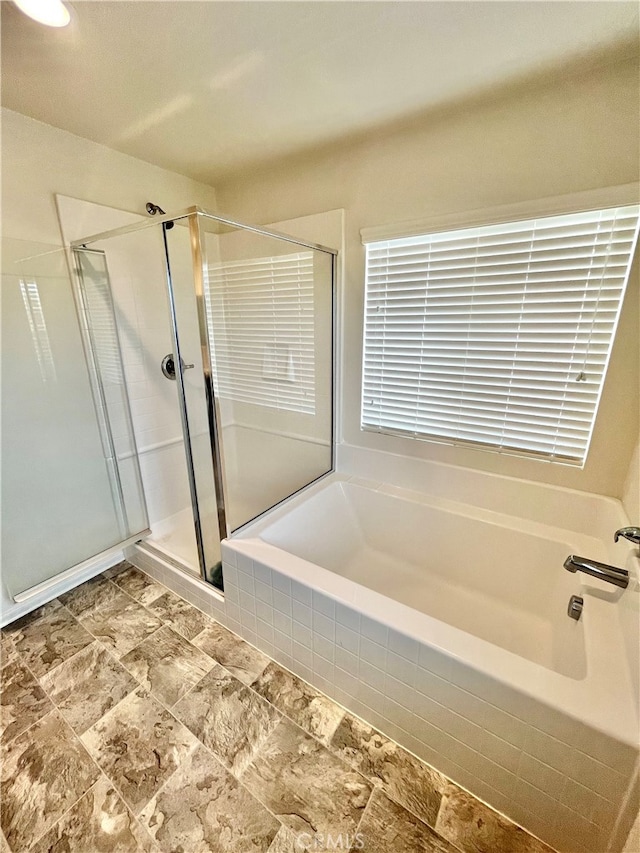 bathroom featuring shower with separate bathtub