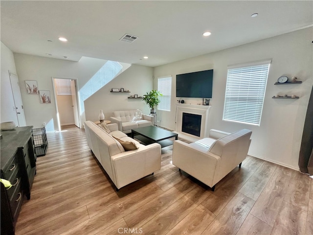 living room featuring light hardwood / wood-style floors and a skylight