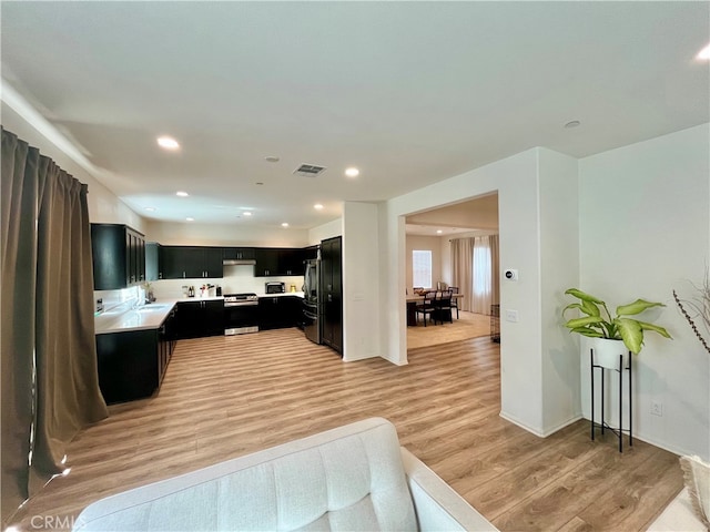 kitchen featuring light hardwood / wood-style flooring and black fridge