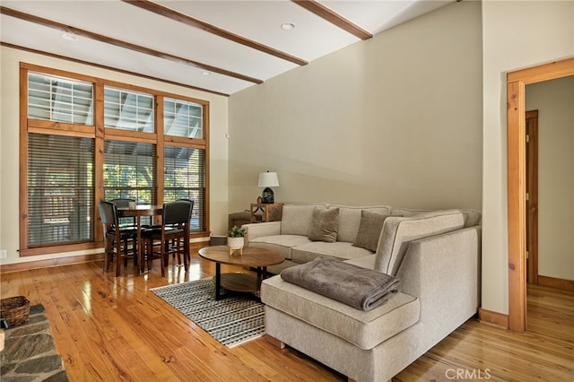 living room featuring beamed ceiling and hardwood / wood-style flooring