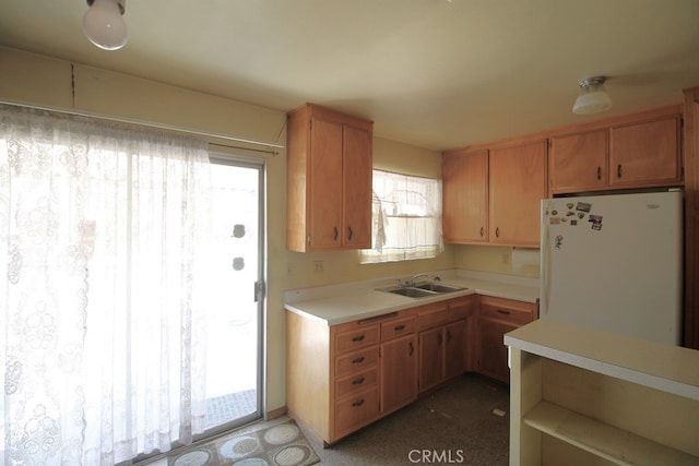 kitchen with white refrigerator, sink, and a wealth of natural light