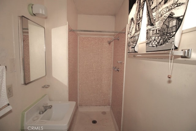 bathroom featuring a tile shower and sink