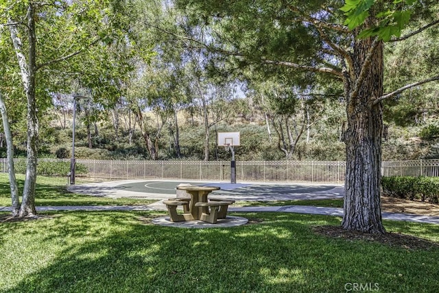 view of sport court featuring a lawn