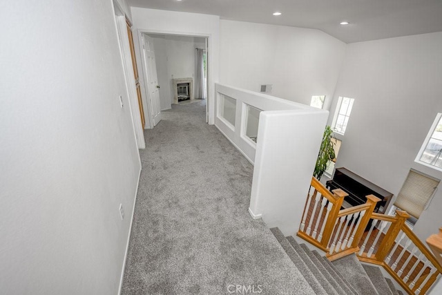 hallway featuring a towering ceiling and light carpet