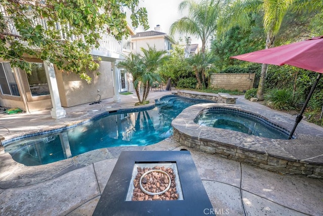 view of pool featuring a fire pit, a patio area, and an in ground hot tub