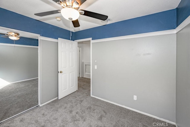 unfurnished bedroom featuring carpet flooring, ceiling fan, and a closet