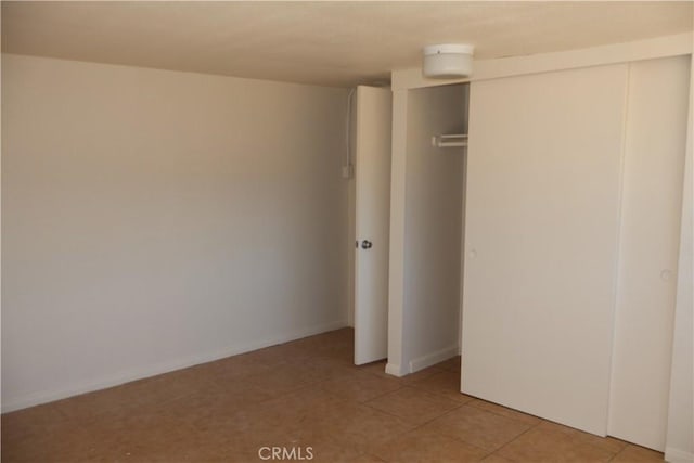 6052 Chia Ave Unit 29, Palms, CA 92277 - unfurnished bedroom with a closet, light tile patterned floors, and baseboards