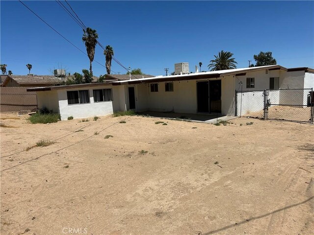 6052 Chia Ave Unit 29, Palms, CA 92277 - rear view of property with stucco siding and fence