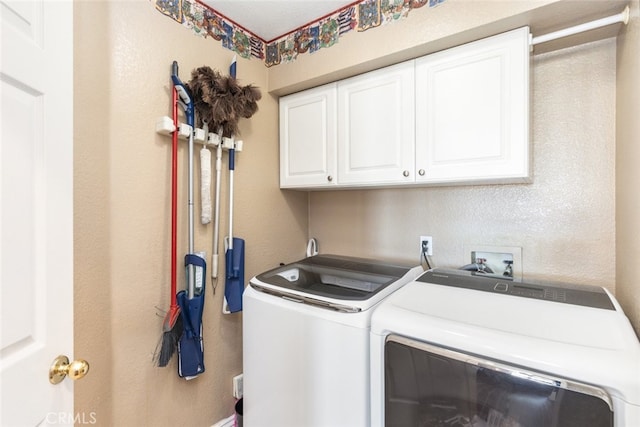 washroom featuring independent washer and dryer and cabinets