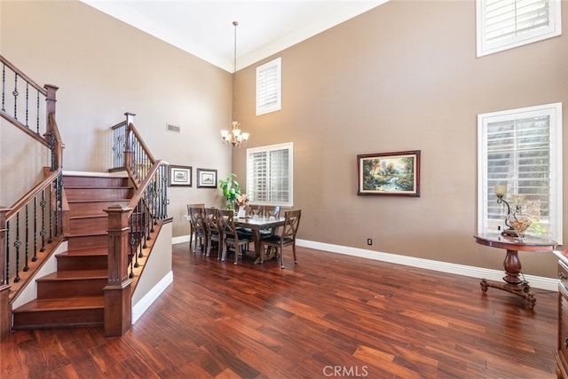 dining area featuring dark hardwood / wood-style flooring, an inviting chandelier, and a wealth of natural light