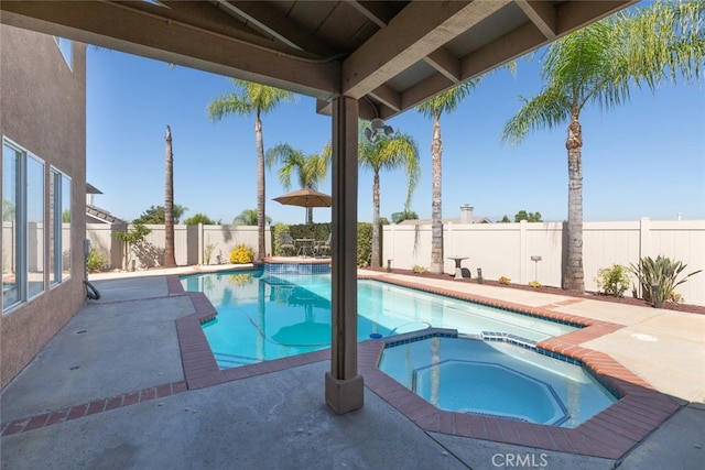 view of pool with a patio area and an in ground hot tub