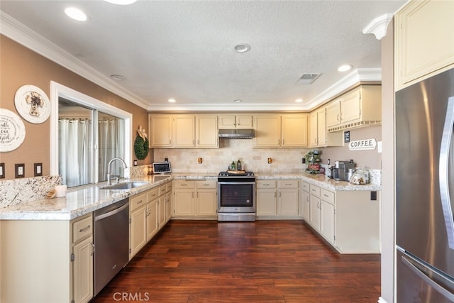 kitchen featuring ornamental molding, dark hardwood / wood-style floors, sink, cream cabinetry, and stainless steel appliances