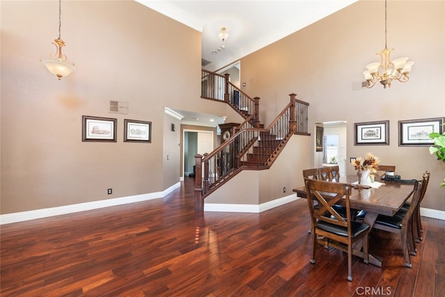 dining room featuring ornamental molding, a high ceiling, dark hardwood / wood-style floors, and an inviting chandelier