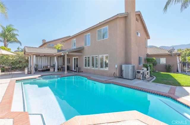 rear view of house with a pergola, a fenced in pool, a patio area, a mountain view, and central AC