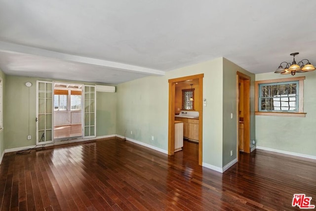 unfurnished room with an AC wall unit, dark hardwood / wood-style flooring, beamed ceiling, and an inviting chandelier