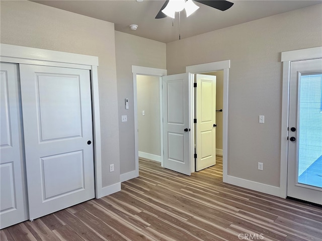 unfurnished bedroom featuring ceiling fan, hardwood / wood-style flooring, and a closet