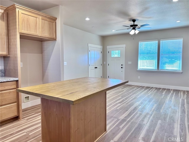 kitchen featuring light hardwood / wood-style floors, a textured ceiling, butcher block counters, ceiling fan, and light brown cabinetry