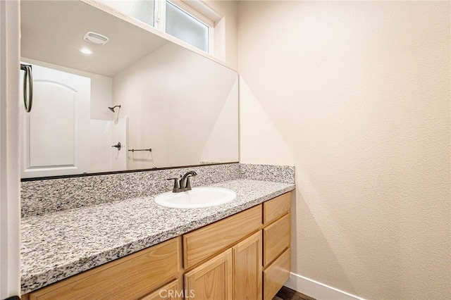 bathroom featuring a shower and vanity