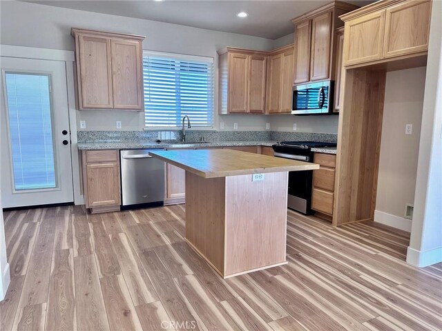 kitchen featuring a kitchen island, sink, light hardwood / wood-style flooring, and stainless steel appliances