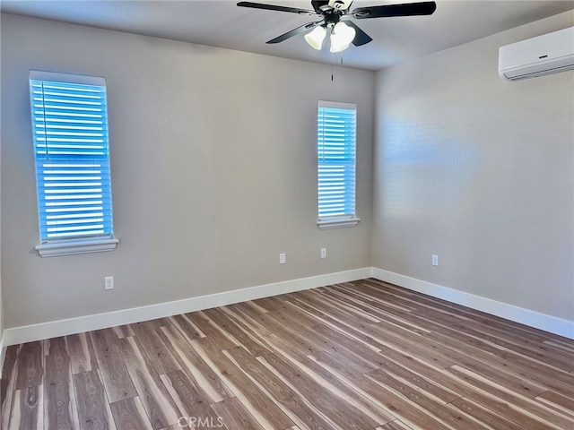 empty room with wood-type flooring, ceiling fan, and a wall mounted air conditioner