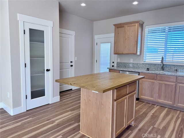 kitchen with a kitchen island, light brown cabinetry, dark hardwood / wood-style floors, sink, and wood counters