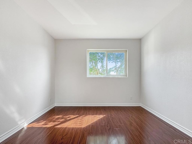 spare room with dark hardwood / wood-style flooring