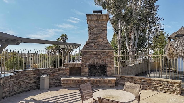 view of patio featuring an outdoor stone fireplace