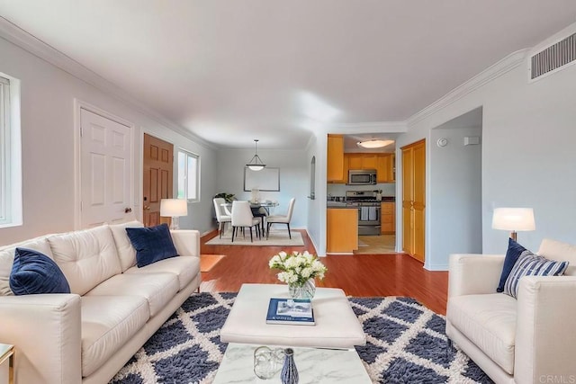 living room with ornamental molding and wood-type flooring