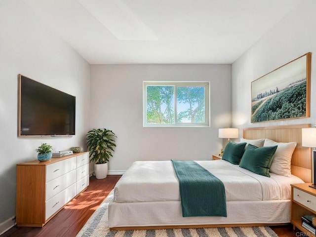 bedroom with dark hardwood / wood-style flooring