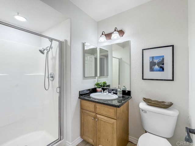 bathroom with an enclosed shower, vanity, and toilet