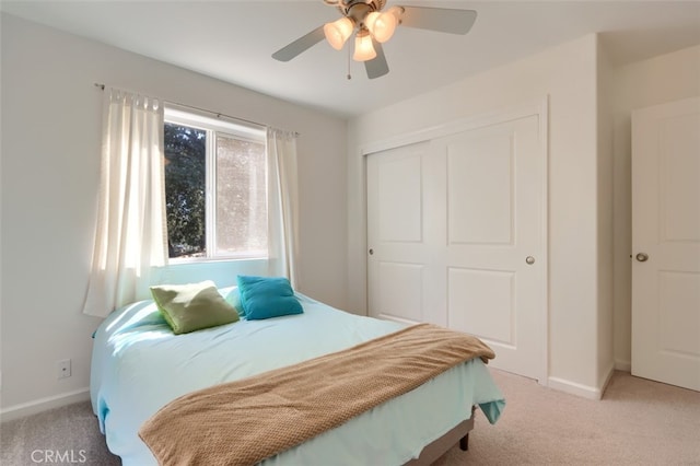 carpeted bedroom featuring ceiling fan and a closet