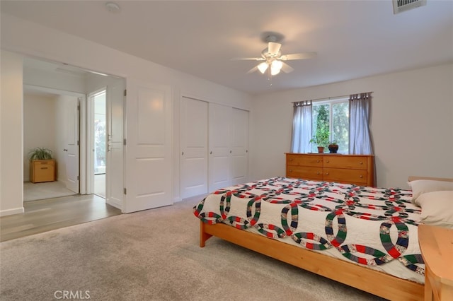 carpeted bedroom featuring ceiling fan and a closet