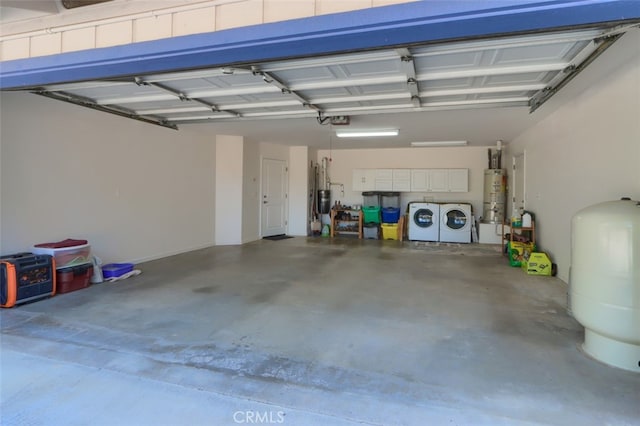 garage featuring separate washer and dryer, water heater, and a garage door opener