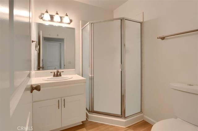 bathroom with vanity, wood-type flooring, an enclosed shower, and toilet