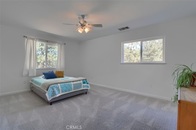 carpeted bedroom with multiple windows and ceiling fan