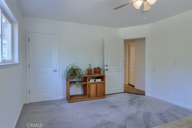 carpeted spare room featuring ceiling fan