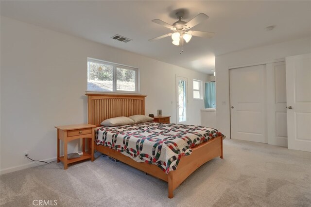 carpeted bedroom with ceiling fan and a closet