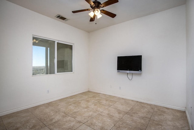 tiled spare room featuring ceiling fan