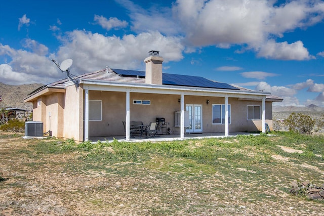 back of property featuring solar panels, a patio, and central air condition unit