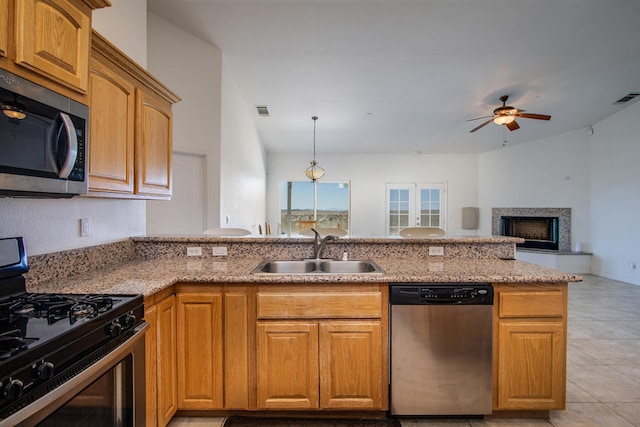 kitchen featuring appliances with stainless steel finishes, kitchen peninsula, light tile patterned floors, ceiling fan, and sink