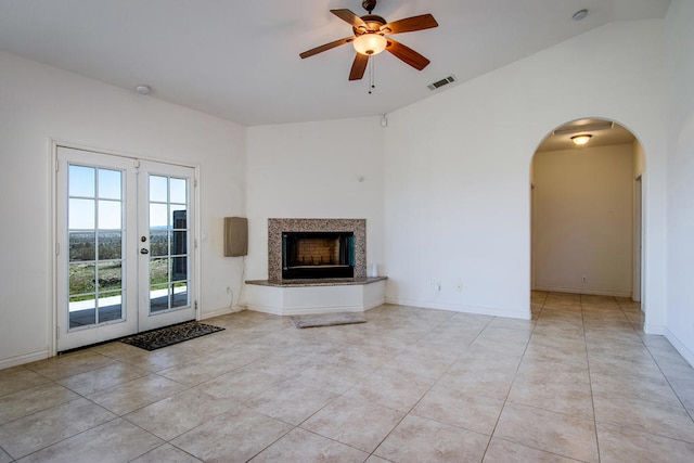 unfurnished living room with light tile patterned floors, vaulted ceiling, ceiling fan, and french doors