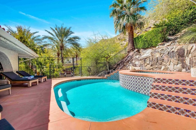 view of swimming pool featuring an in ground hot tub and a patio